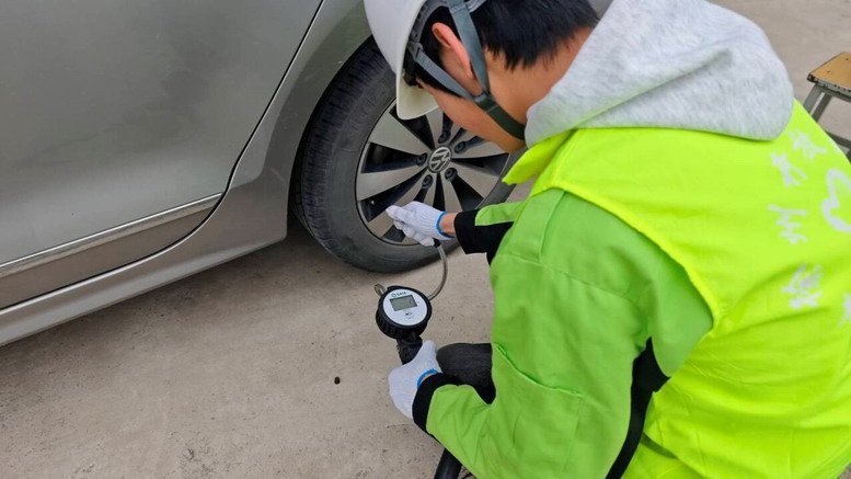 汽車工程學(xué)院團(tuán)支部學(xué)生為教職工車輛做胎壓檢測